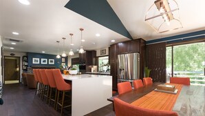 A modern kitchen with a central island, bar stools, and a dining area with a long table. - Well-furnished Hiker's Retreat, Centrally located for visiting the ONP; Sleeps 8 (Port Angeles)
