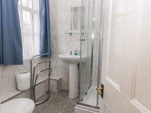 A bathroom with a white sink, a glass shower enclosure, a white toilet, and a blue shower curtain. - Highview (Scarborough)