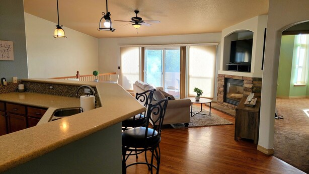 A modern kitchen with a bar area, a dining space with a sofa, and a fireplace. - 5 Bedroom home near downtown with hot tub! (Colorado Springs)