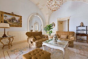 A spacious living room with two sofas, a glass coffee table, and a chandelier. - Villa Nicrys by Perle di Puglia (Maglie)