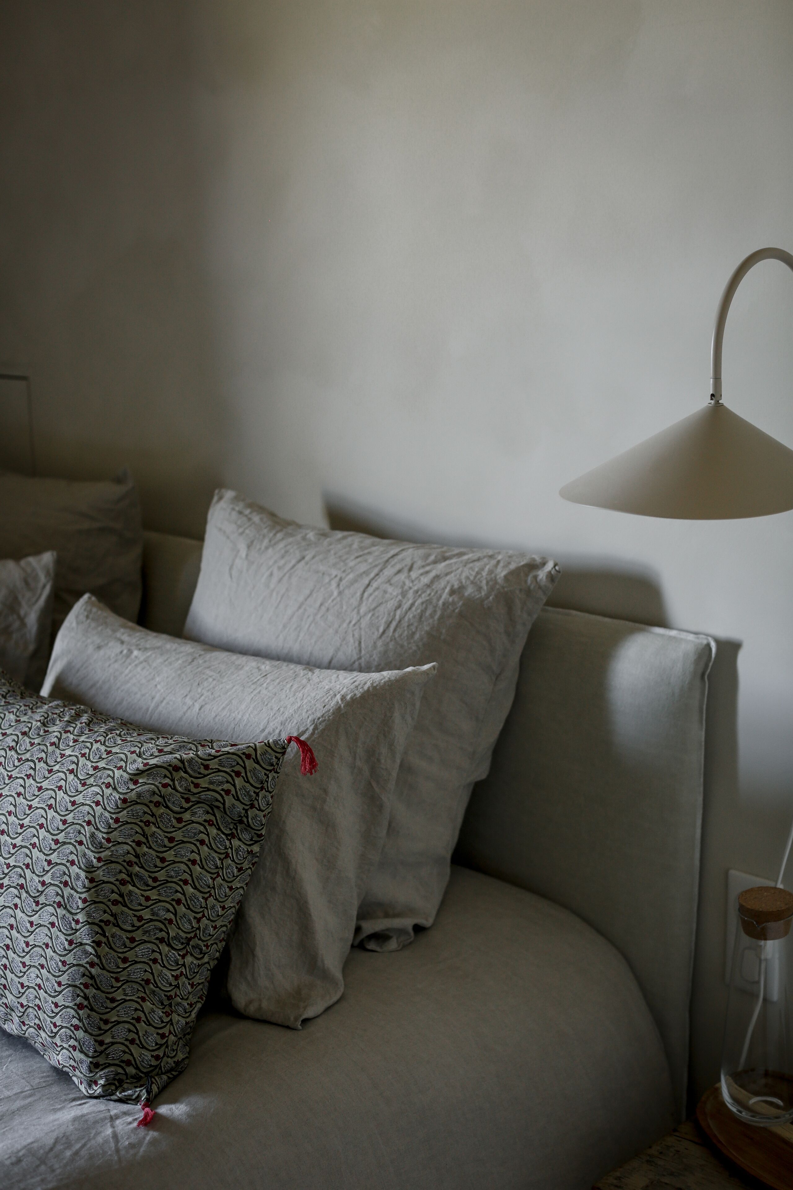 Ein Zimmer mit einem Bett, einer Lampe und einer Steckdose.