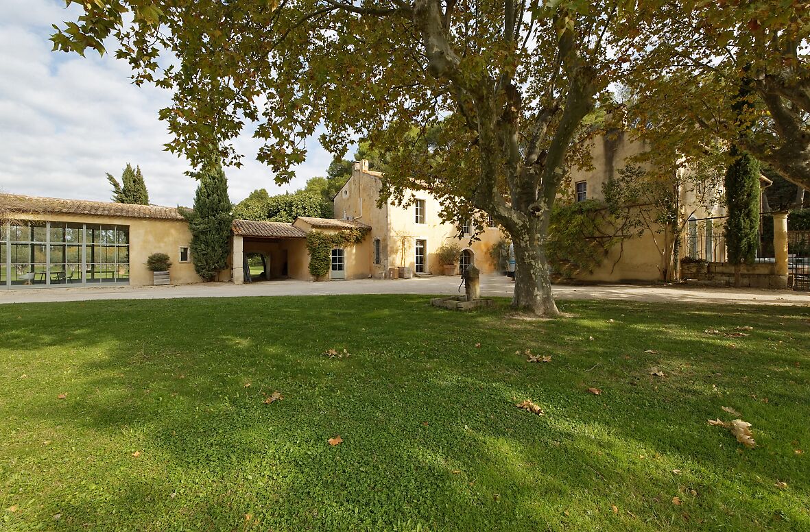 A building with a courtyard, a covered seating area, and a large tree in the center.
