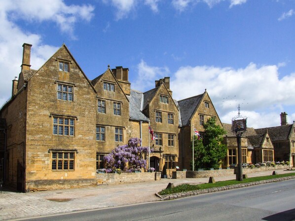 A row of stone buildings with multiple windows and a central flagpole.