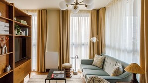Ein Wohnzimmer mit einer Holzhülle, einem Sofa, einem Couchtisch und einer Lampe.