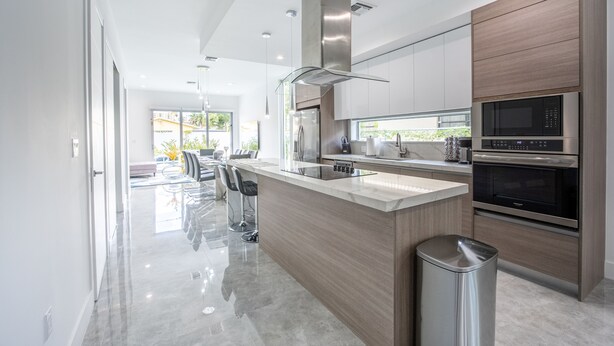 A modern kitchen with a central island, stainless steel appliances, and a view to the outdoors. - NEW Townhouse in Coconut Grove (Coconut Grove)