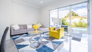 A modern living room with a sofa, yellow armchair, and a glass coffee table. - NEW Townhouse in Coconut Grove (Coconut Grove)