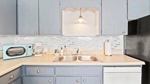 A kitchen with a microwave, coffee maker, and sink. - Beachy Getaway • Clean, Private 3BR (Wendell)