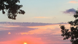 A calm lake with a sailboat at sunset. - Smith's Lake House 4 bedroom, enjoy spectacular sunrises, 2 bathroom, built 2021 (Penn Yan)