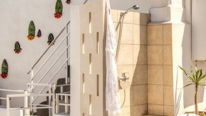 Un bagno moderno con una doccia, un asciugamano bianco appeso al muro e decorazioni a parete.