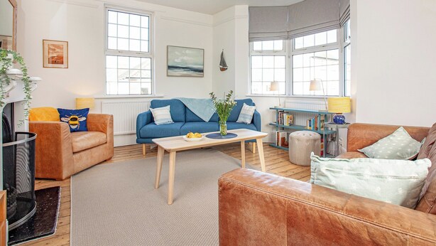 A living room with a blue sofa, a brown sofa, a wooden coffee table, and a bookshelf.