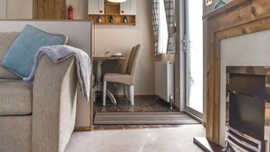 A cozy living room with a sofa, a dining table, and a fireplace. - 2 bedroom accommodation in Robin Hood&rsquo;s Bay (Robin Hood&rsquo;s Bay)