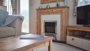 A living room with a fireplace, a television, and a sofa. - 2 bedroom accommodation in Robin Hood&rsquo;s Bay (Robin Hood&rsquo;s Bay)
