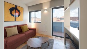 A modern living room with a red sofa, a coffee table, and a large abstract painting. - Gorgeous Modern Flat w/ Balcony by LovelyStay (Porto)