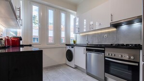 Eine moderne Küche mit Einbauwaschmaschine, Geschirrspüler und Edelstahlbackofen.