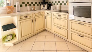A kitchen with white cabinets, a Brandt oven, and a tiled backsplash. - Villa 10 people-Private Pool-250m from the sea (Fréjus)