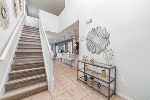 Ein modernes Interieur mit Treppe, Glastische und Wanddekoration.