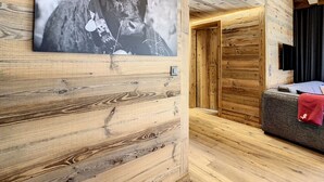Ein Holzinnenraum mit einem großen gerahmten Bild an der Wand, einem Sofa und einem an der Wand befestigten Fernseher.