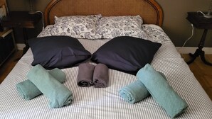 A bed with striped bedding, two dark pillows, and two rolled towels. - Authentic Quercy house, between Périgord and Quercy (Peyrilles)