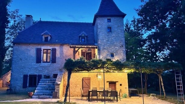 A stone house with a tower, a covered patio with chairs, and a staircase leading to the entrance. - Authentic Quercy house, between Périgord and Quercy (Peyrilles)