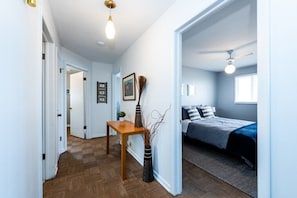 Een slaapkamer met een bed, nachtkastje en raam.