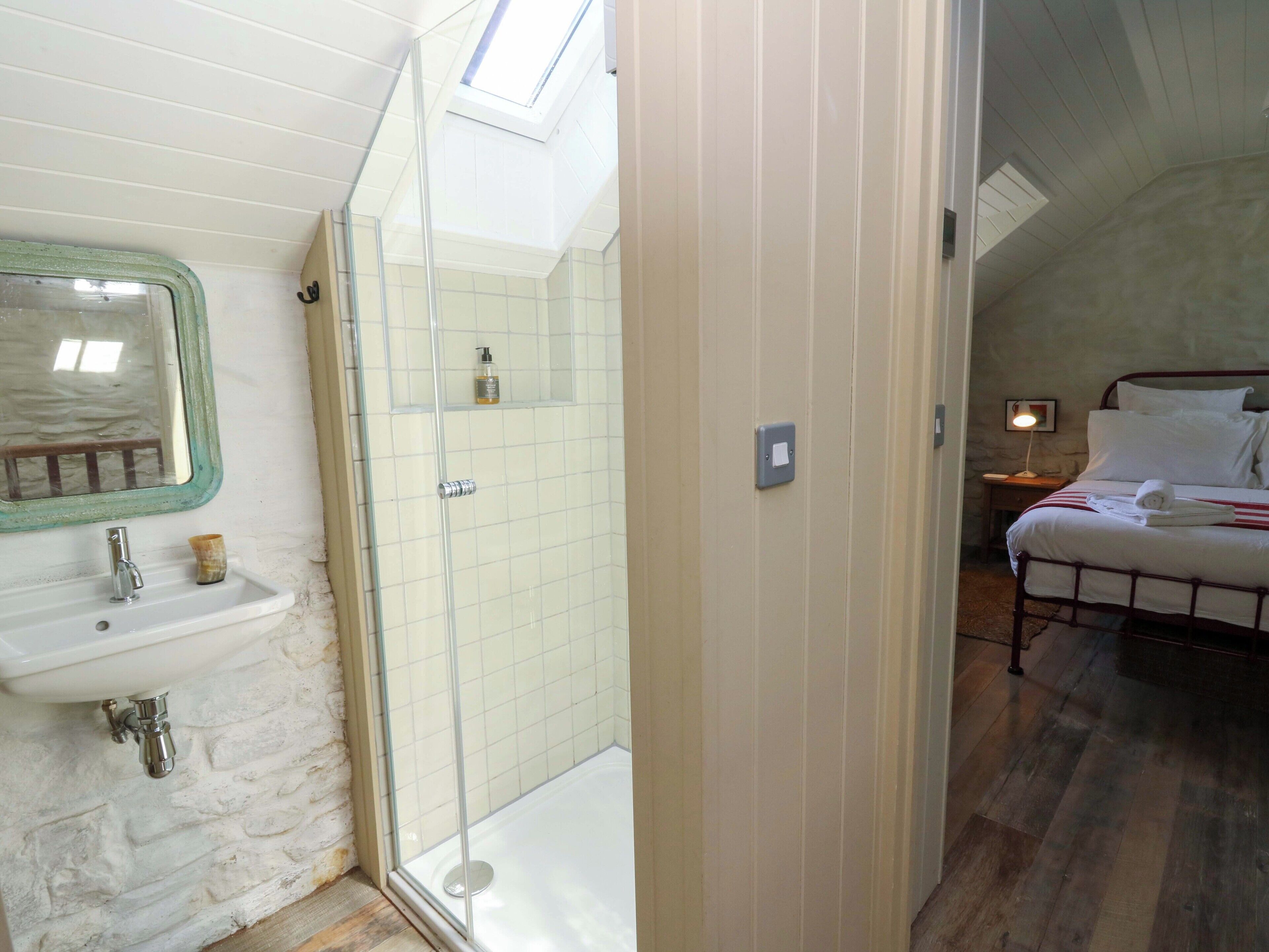 Ein Badezimmer mit Waschbecken, Spiegel und Dusche.