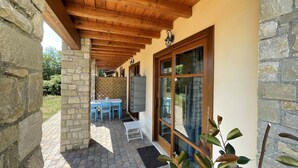 A covered patio with stone walls, a wooden ceiling, and a table with chairs. - BLU Flat (2 pax) + 2 Bunks Bed, FIOCCHINA magic place - Salò - Garda Lake (Lombardia)