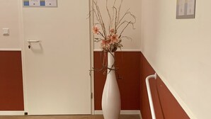 A staircase with a white door and a white vase with flowers. - Apartment 1, centrally located on the waterfront (Emden)
