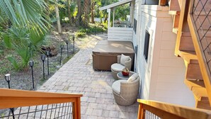 A patio area with a hot tub, wicker furniture, and a brick pathway. - Guesthouse/TPC/GuanaViews/WalkBeach/HotTub (Ponte Vedra Beach)