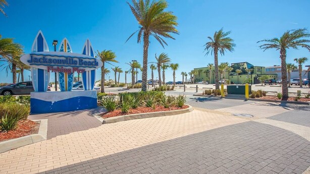A sign for Jacksonville Beach Fishing Pier with palm trees and a paved walkway. - Guesthouse/TPC/GuanaViews/WalkBeach/HotTub (Ponte Vedra Beach)