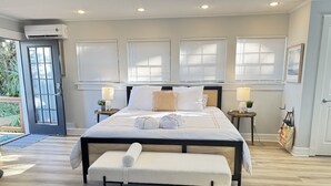 A neatly arranged bedroom with a large bed, bedside tables, and a bench. - Guesthouse/TPC/GuanaViews/WalkBeach/HotTub (Ponte Vedra Beach)