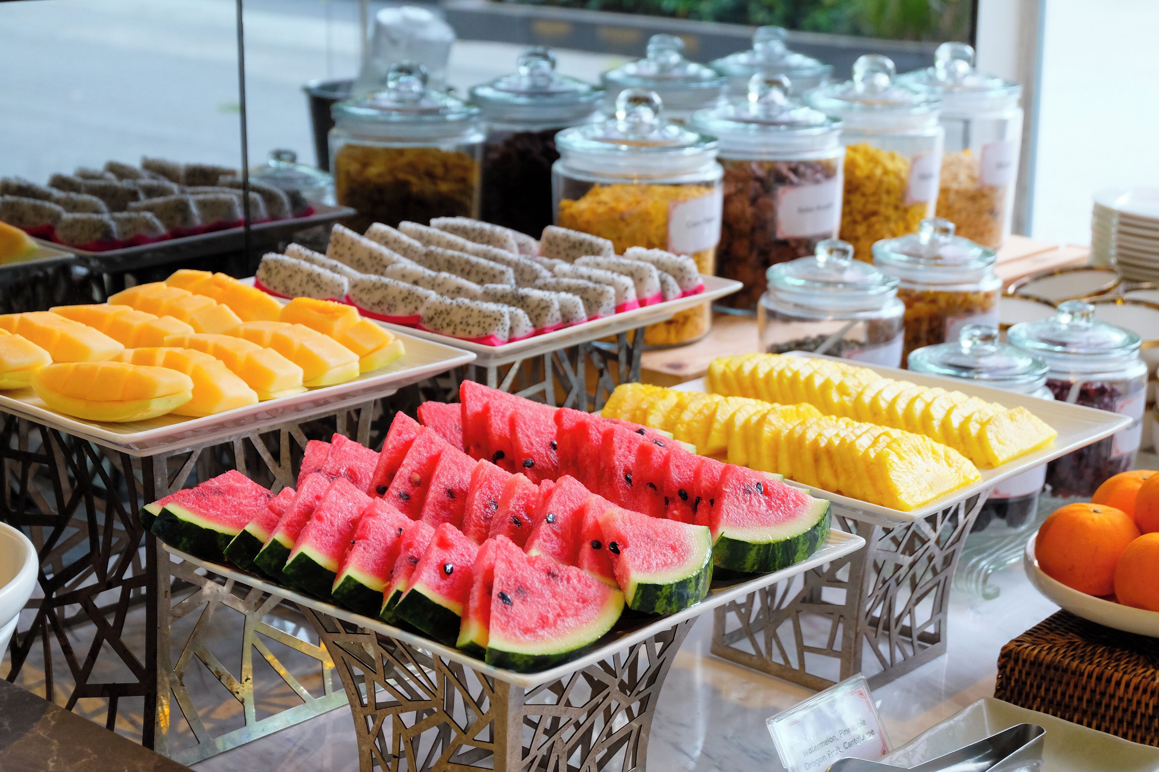 A buffet with various fruits and desserts.