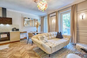 Ein modernes Wohnzimmer mit einer Couch, einem Esstisch und einer Küchenzeile.