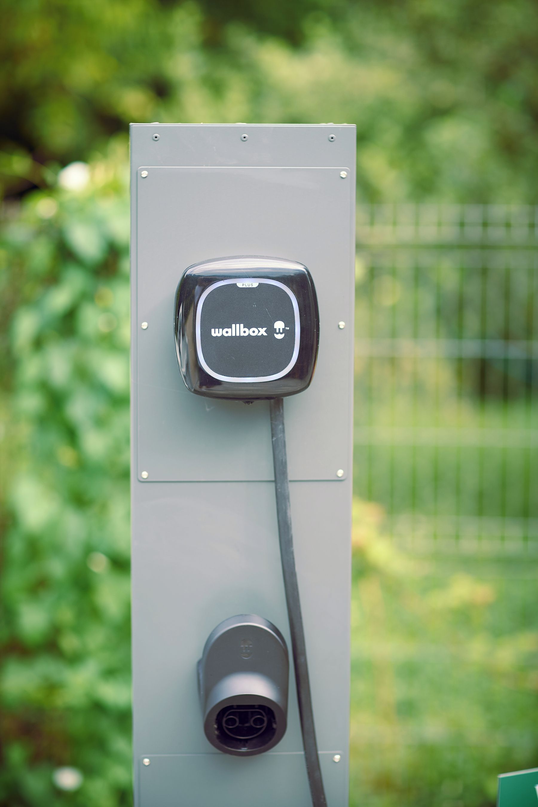 A wallbox with a plug connected to a charging station.