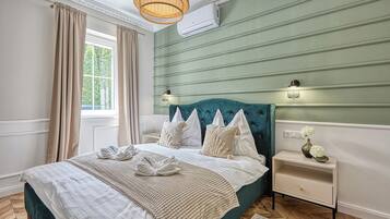 Ein stilvoll eingerichtetes Schlafzimmer mit einem großen Bett, einem Nachttisch, einer Kommode und einem Fenster mit Vorhängen.