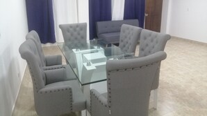 A conference room with a glass table surrounded by four grey upholstered chairs with button-tufted backs. - San Andrés Central Apartment 10 (San Andrés)