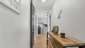 A narrow hallway with a wooden bench and a large vase on a table. - Nostalgic in Nelsonville: Great back yard for pets (Nelsonville)