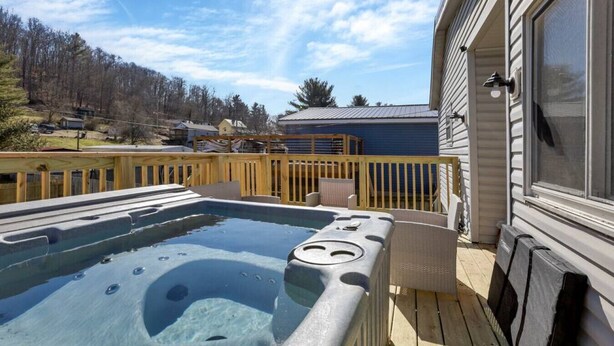 A hot tub on a wooden deck with a view of a house and trees in the background. - Nostalgic in Nelsonville: Great back yard for pets (Nelsonville)