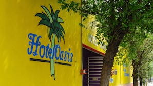 A yellow wall with the text "Hotel Oasis" and a palm tree graphic. - OYO Hotel Oasis, Monterrey (Monterrey)