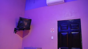 A room with a closed door, a mounted television, and a no-smoking sign on the wall. - OYO Hotel Oasis, Monterrey (Monterrey)