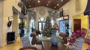 Een ruime lobby met een hoge plafond, een grote kerstboom en comfortabele zitgedeeltes.