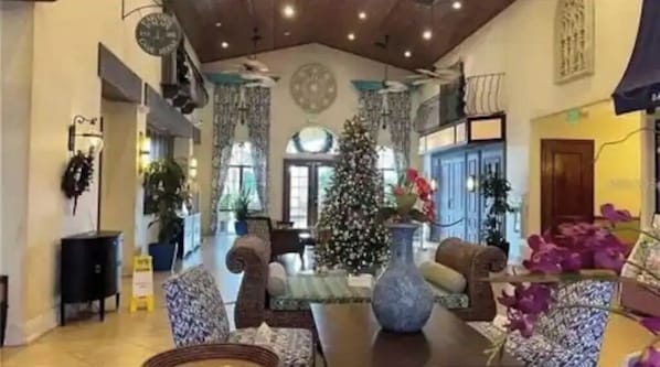 Eine geräumige Lobby mit hoher Decke, einem großen Weihnachtsbaum und gemütlichen Sitzbereichen.