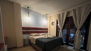 A hotel room with a bed, a nightstand, a wall clock, and a window with curtains. - Sete Mares (Maragogi)