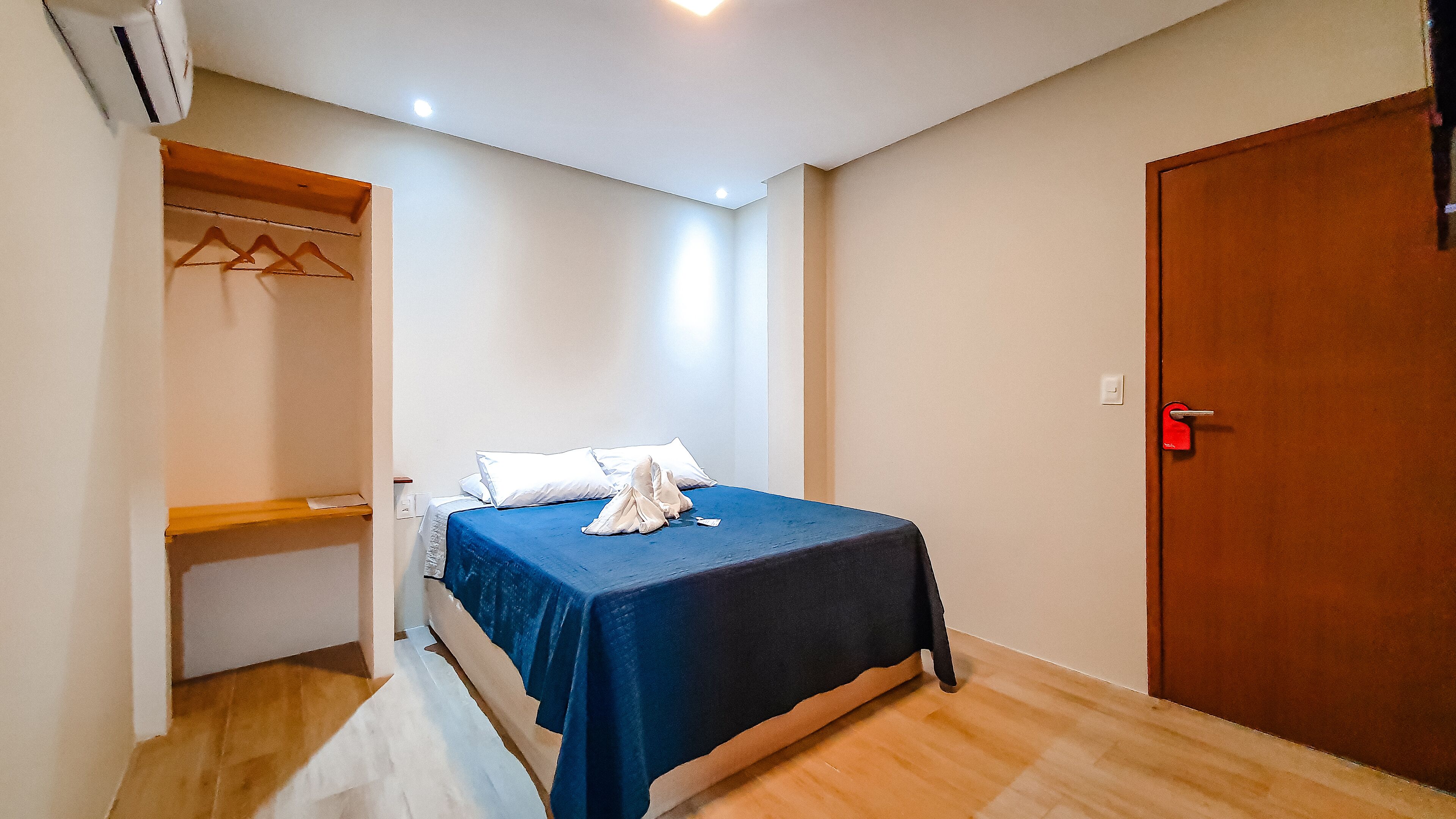 A bedroom with a bed, a wardrobe, and a door.
