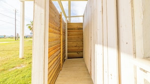 A narrow wooden staircase leading to a covered porch area with a view of the surrounding landscape. - Pet Friendly - Walk to the Beach, Cozy Home (Freeport)