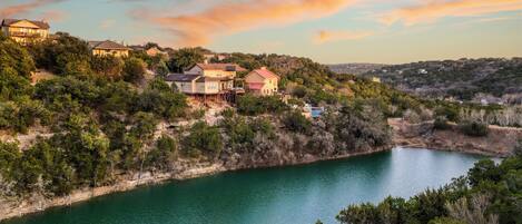 A hillside residential area with houses overlooking a calm lake.
