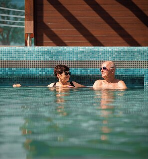 A swimming pool with tiled walls and a wooden structure in the background. - Cozy 1 bedroom apartment with jacuzzi (Mosonmagyarovar)
