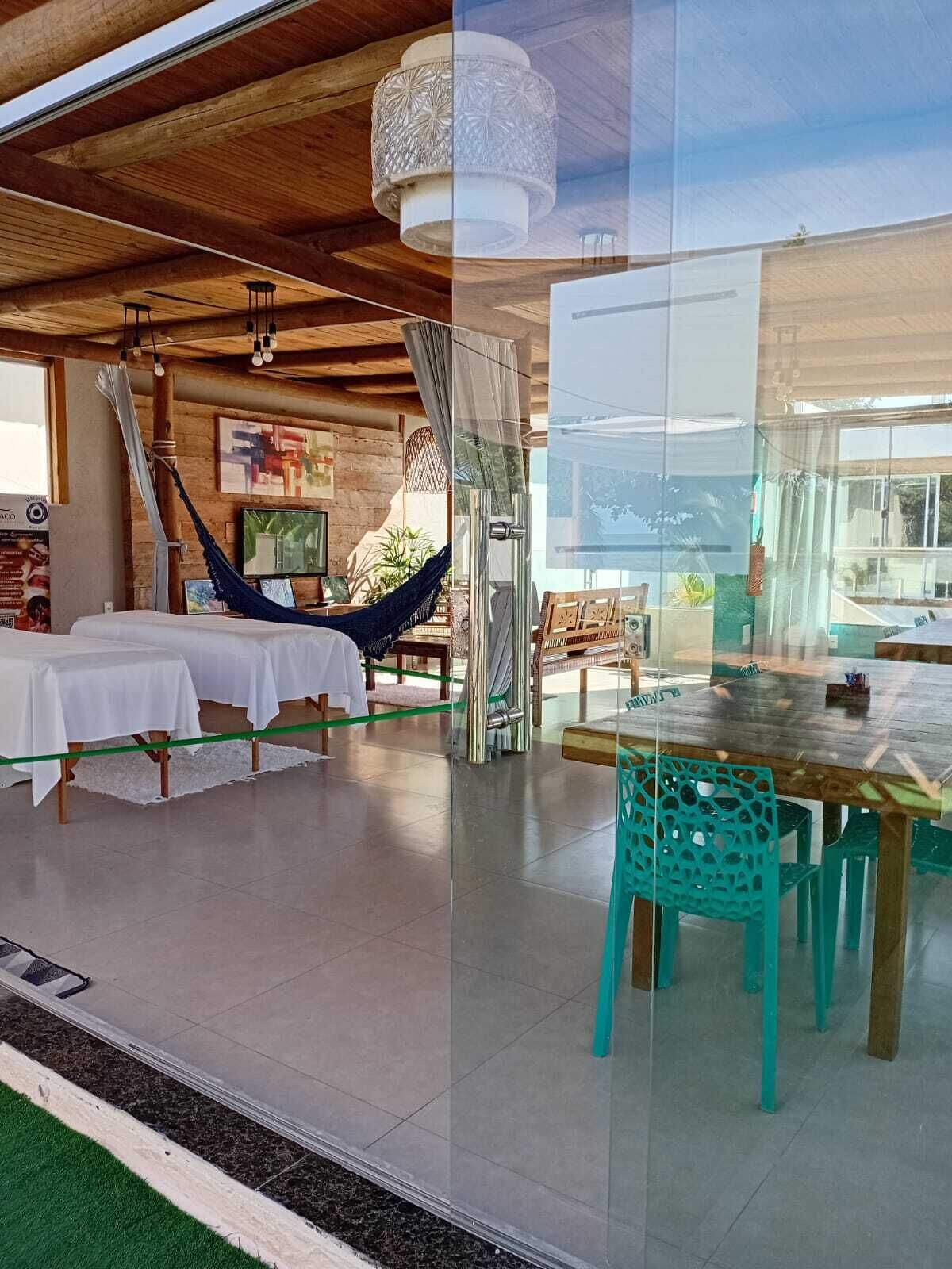 A room with a hammock, a whiteboard, and a dining area with teal chairs.