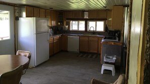 Una cocina compacta con armarios de madera, un refrigerador, un lavabo y una estufa.