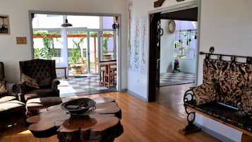 Una sala de estar con piso a cuadros, chimenea y vista al balcón exterior.
