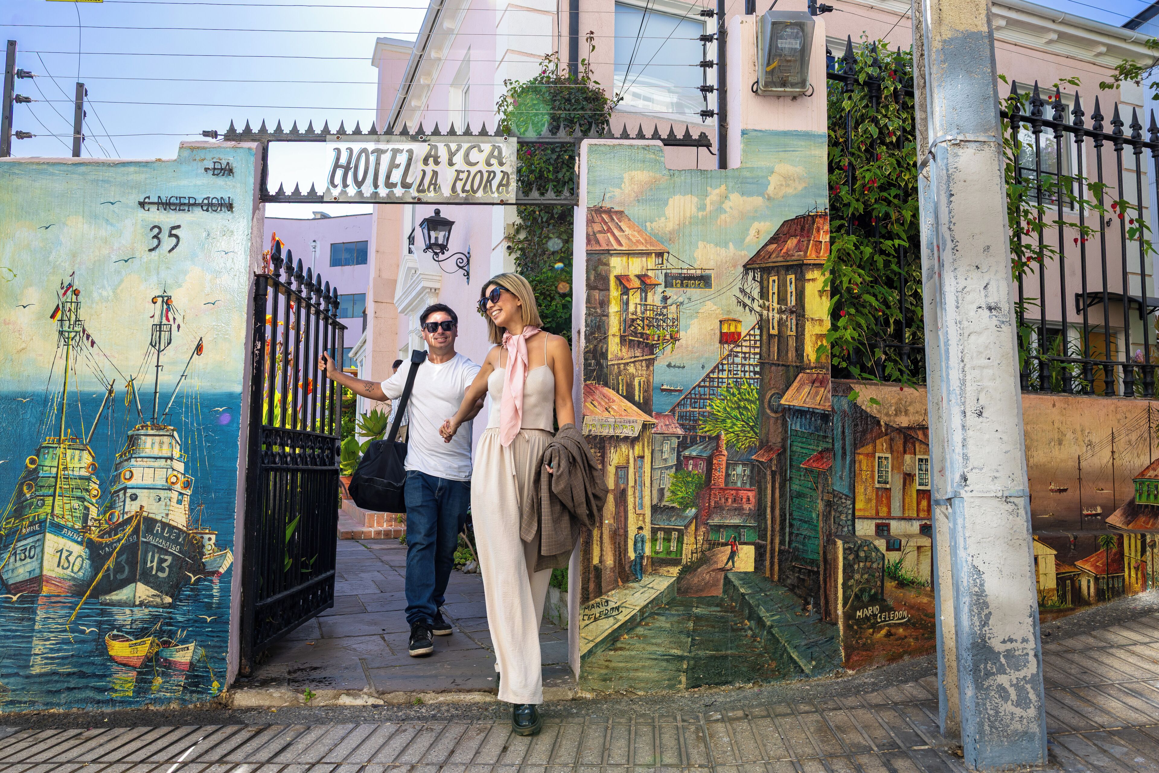 A hotel entrance with a colorful mural of boats and buildings.